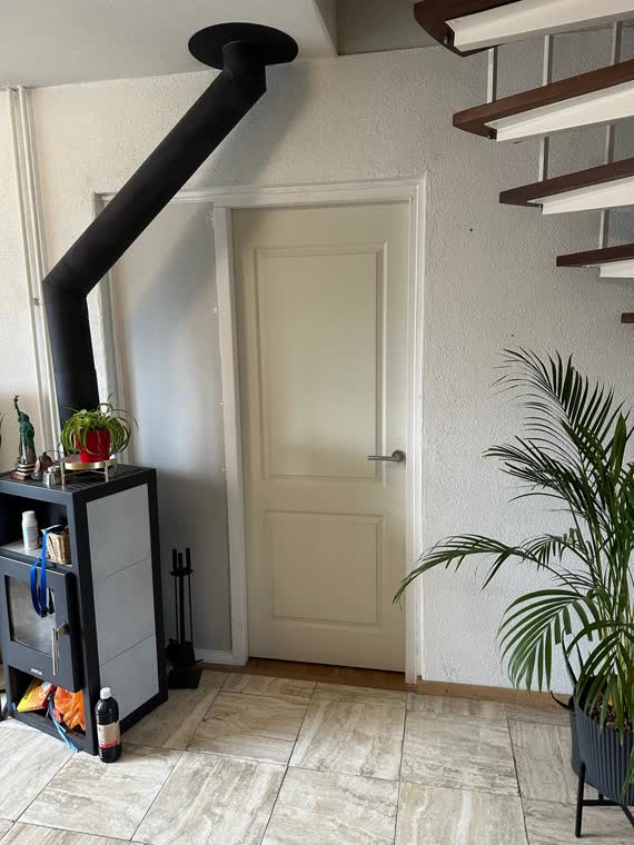 Nieuwe binnendeur onder de open trap, naast de kachel
